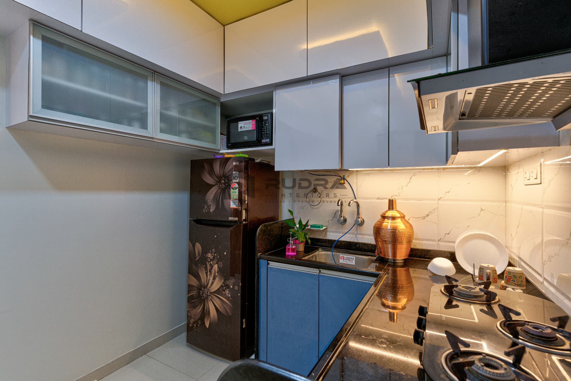 Compact modular kitchen with glass wall units and chimney